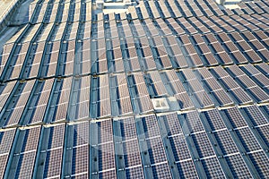 Aerial view of many photo voltaic solar panels mounted of industrial building roof