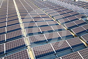 Aerial view of many photo voltaic solar panels mounted of industrial building roof