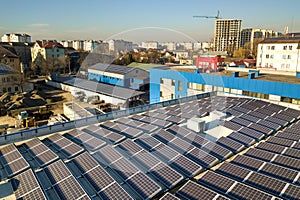 Aerial view of many photo voltaic solar panels mounted of industrial building roof