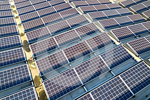 Aerial view of many photo voltaic solar panels mounted of industrial building roof