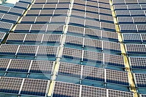 Aerial view of many photo voltaic solar panels mounted of industrial building roof