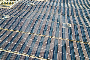 Aerial view of many photo voltaic solar panels mounted of industrial building roof