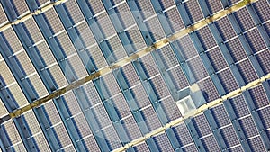 Aerial view of many photo voltaic solar panels mounted of industrial building roof.