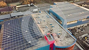 Aerial view of many solar panels mounted of industrial building roof.