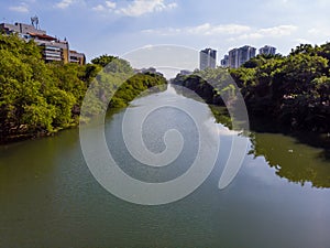 Aerial view of Marapendi canal in Barra da Tijuca on a summer day. Tall residential skyscrapers on both sides, with