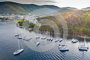 Aerial view of marina Vis at sunset, Croatia, a lot of chaotically standing boats in a bay, roofs of orange color