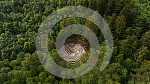 Aerial view of a maze in a park in the middle of a lush forest