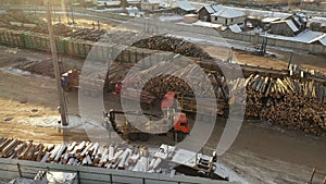 Aerial view of mechanical gripper loading lumber on to truck for transportation. Forest cutting concept. A logging train