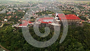 Aerial view of medieval castle on mountain in small european city at cloudy autumn day