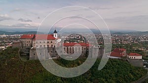 Aerial view of medieval castle on mountain in small european city at cloudy autumn day