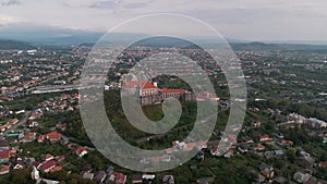 Aerial view of medieval castle on mountain in small european city at cloudy autumn day