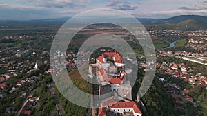 Aerial view of medieval castle on mountain in small european city at cloudy autumn day