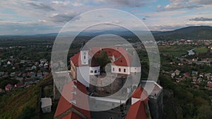 Aerial view of medieval castle on mountain in small european city at cloudy autumn day