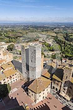 Aerial view of the medieval houses, central sqare and towers of San Gimignano, Italy, and the surrounding landscape