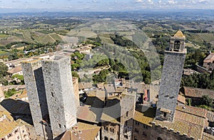 Aerial view of the medieval houses, central sqare and towers of San Gimignano, Italy, and the surrounding landscape