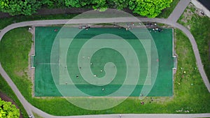 Aerial view of men playing football on a public city soccer field