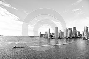 Aerial view of Miami skyscrapers with blue cloudy sky, boat sail