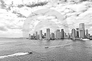 Aerial view of Miami skyscrapers with blue cloudy sky, boat sail