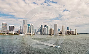 Aerial view of Miami skyscrapers with blue cloudy sky, boat sail