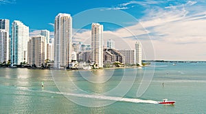 Aerial view of Miami skyscrapers with blue cloudy sky, boat sail