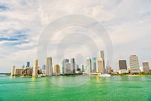 Aerial view of Miami skyscrapers with blue cloudy sky, boat sail