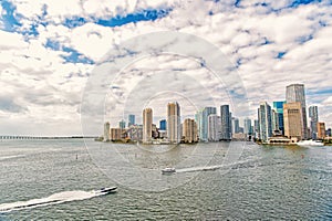 Aerial view of Miami skyscrapers with blue cloudy sky, boat sail