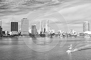 Aerial view of Miami skyscrapers with blue cloudy sky, boat sail