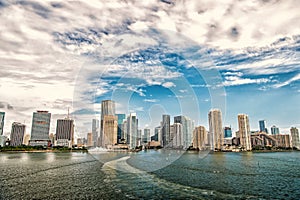 Aerial view of Miami skyscrapers with blue cloudy sky, boat sail