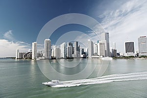 Aerial view of Miami skyscrapers with blue cloudy sky, boat sail