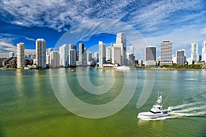 Aerial view of Miami skyscrapers with blue cloudy sky, boat sail
