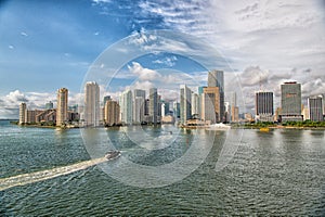 Aerial view of Miami skyscrapers with blue cloudy sky, boat sail