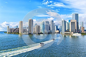 Aerial view of Miami skyscrapers with blue cloudy sky, boat sail