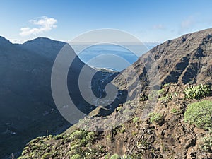 Aerial view from Mirador de la curva del queso. Green valley of Valle Gran Rey with mountain cliffs, ocean and colorful