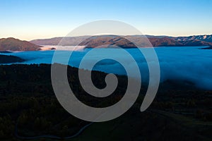 Aerial view of mist and clouds in the valley in sunrise