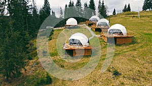 Aerial view Modern futuristic houses in the white round forest. Young couple in love near the house.