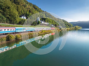 Aerial view of modern high speed train moving near river