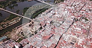 Aerial view of modern Merida cityscape on banks of Guadiana River with ancient pedestrian Roman Bridge, Spain