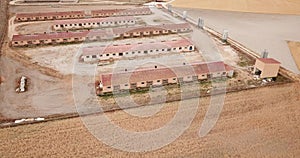 Aerial view of modern pig farm buildings in fields at summer day
