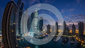 Aerial view of modern skyscrapers night to day timelapse before sunrise in Dubai Marina in Dubai, UAE.