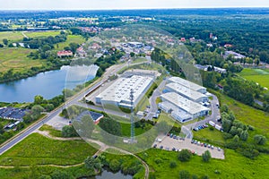 Aerial view of modern storage warehouse with solar panels on the roof. Logistics center in industrial city zone from drone view.