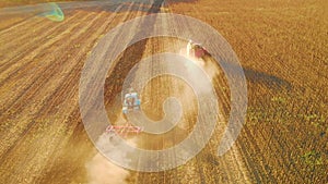 Aerial view modern tractor on the agricultural field on sunset time. Tractor plowing land and cultivating field.