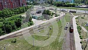 Aerial view of modern tram riding in city. Bird`s eye view of contemporary tram riding on rails on sunny day.