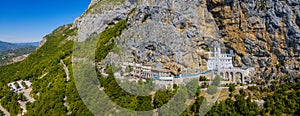 Aerial view of The Monastery of Ostrog, Serbian Orthodox Church situated against a vertical background. Montenegro.