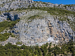 Aerial view of The Monastery of Ostrog, Serbian Orthodox Church situated against a vertical background. Montenegro.