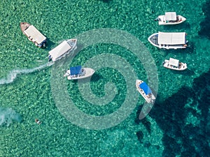 Aerial view of moored boats floating on a transparent sea
