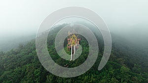 Aerial view at morning mist Wat Phra That Doi Phra Chan. and Daibutsu Buddha on the greenery mountain in the rainforest north of