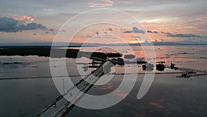 Aerial view: Motorbikes moving on the road pier in the Philippines at dusk.