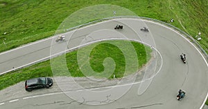 Aerial view of Motorcycles driving hairpin Road in the Alps. Top down view