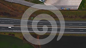 Aerial view of a motorway. Camera move left with a view on cars running on the highway and the road. A lot of vehicles ride on the