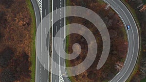 Aerial view of a motorway. Camera move up with a view on cars running on the highway and the road. A lot of vehicles ride on the f